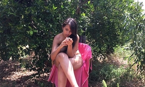 Chica joven de eighteen anos sentada desnuda entre árboles